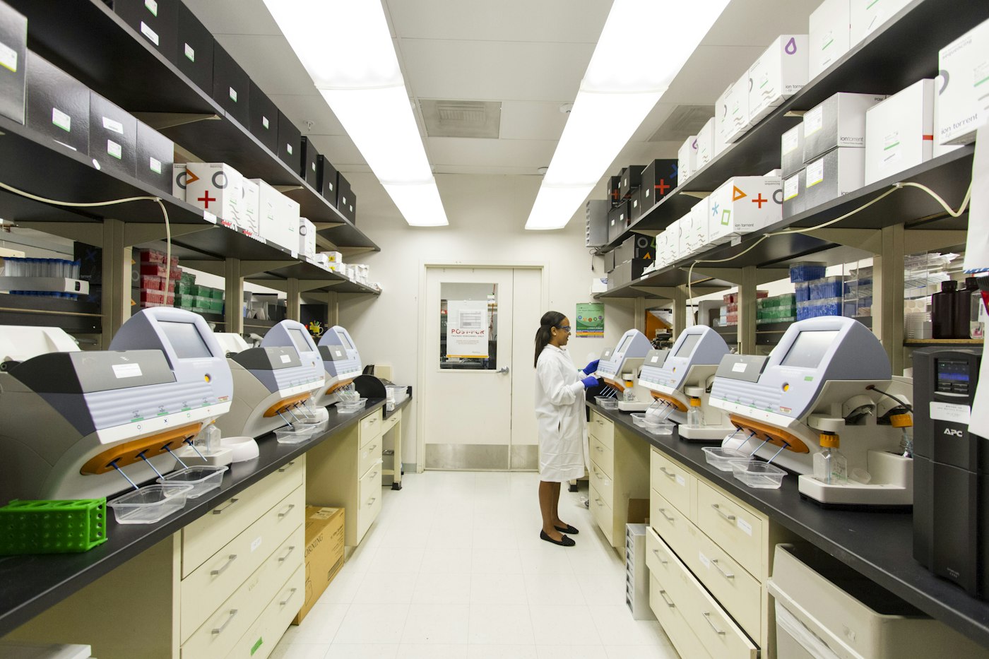 Technician working among genomic sequencing machines