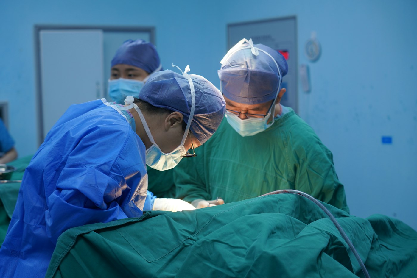 Surgeons in blue scrubs during a procedure